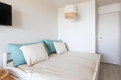 a white couch with pillows in a living room at Studio vue mer Cannes - Piscine - Tennis - Clim in Cannes