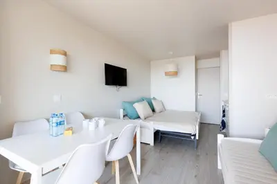 a living room with a white table and chairs at Studio vue mer Cannes - Piscine - Tennis - Clim in Cannes