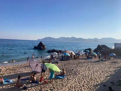 a group of people on a beach with umbrellas at Cannes, Sea View, Beach Access, 3-Bedroom Apartment, 100 m2, 3 Bathrooms, Sleeps 6, 100 meters from Beach in Cannes