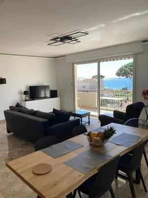 a living room with a table and a couch at Cannes, Sea View, Beach Access, 3-Bedroom Apartment, 100 m2, 3 Bathrooms, Sleeps 6, 100 meters from Beach in Cannes