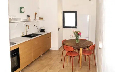 a kitchen with a table and two chairs and a sink at La maison by Simone T3 in Cannes