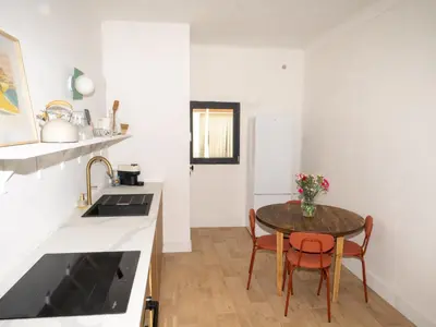 a kitchen with a table and chairs in a room at La maison by Simone T3 in Cannes