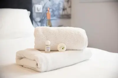 a stack of towels with a baby bottle on it at Modern and renovated apartments next to the CROISETTE and PALAIS DES FESTIVALS in Cannes