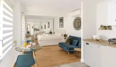 a white living room with a bed and a table at Modern and renovated apartments next to the CROISETTE and PALAIS DES FESTIVALS in Cannes