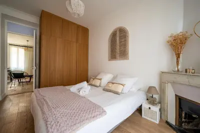 a bedroom with a white bed and a fireplace at B016 - Beautiful apt For 4 - Cannes center in Cannes