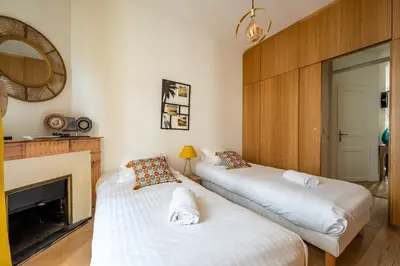 two beds in a room with a fireplace at B016 - Beautiful apt For 4 - Cannes center in Cannes