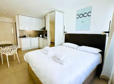 a bedroom with a large white bed with towels on it at Renovated studio near the CROISETTE in Cannes
