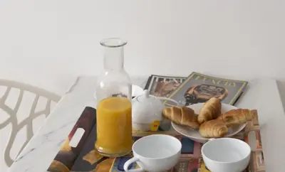 a table with a plate of pastries and a bottle of orange juice at Renovated studio near the CROISETTE in Cannes
