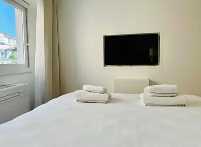 a bedroom with white towels on a bed with a television at Renovated studio near the CROISETTE in Cannes