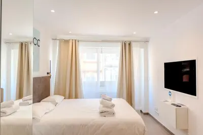 a hotel room with two beds and a television at Renovated studio near the CROISETTE in Cannes
