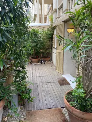 a wooden walkway with potted plants and a building at Les Fleurs in Cannes