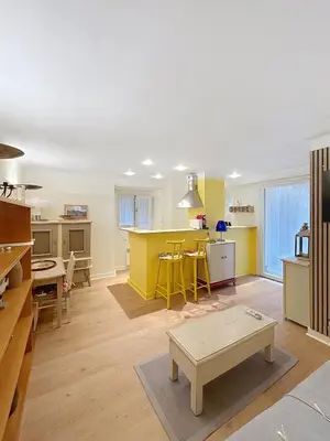 a living room with a kitchen with yellow walls at Les Fleurs in Cannes