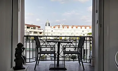a balcony with a table and chairs and a view of a building at LA CROISETTE élégant studio avec balcon et vue mer aperçu in Cannes