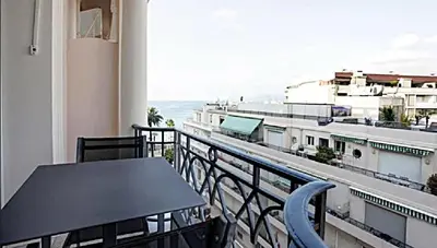 a balcony with a table and a view of a building at LA CROISETTE élégant studio avec balcon et vue mer aperçu in Cannes
