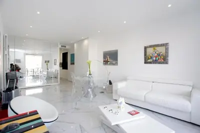 a white living room with a white couch and a table at LA CROISETTE élégant studio avec balcon et vue mer aperçu in Cannes