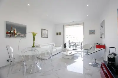 a white living room with a table and chairs at LA CROISETTE élégant studio avec balcon et vue mer aperçu in Cannes