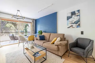 a living room with a couch and a table at LE FLEURI avec terrasse, à côté du Martinez, idéal pour un séjour plaisant in Cannes