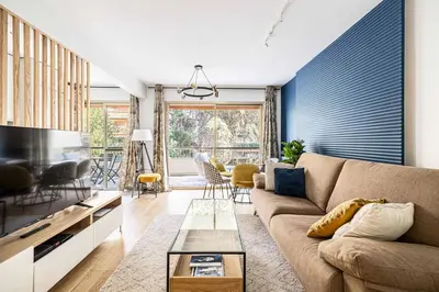 a living room with a couch and a tv at LE FLEURI avec terrasse, à côté du Martinez, idéal pour un séjour plaisant in Cannes