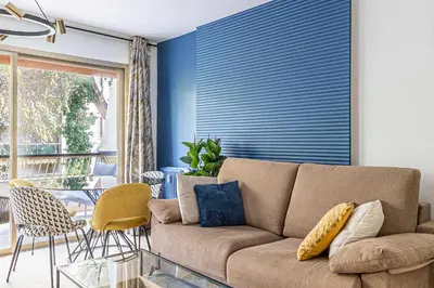a living room with a couch and a glass table at LE FLEURI avec terrasse, à côté du Martinez, idéal pour un séjour plaisant in Cannes