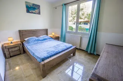 a bedroom with a wooden bed and a window at La fourmi in Cannes