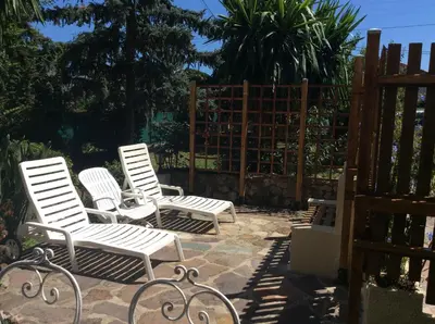 three white chairs sitting on a patio next to a fence at La fourmi in Cannes
