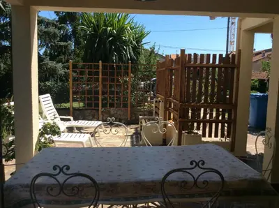 a patio with a table and chairs and a fence at La fourmi in Cannes