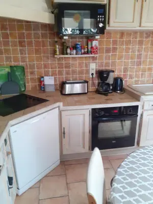 a kitchen with white cabinets and a stove top oven at La fourmi in Cannes