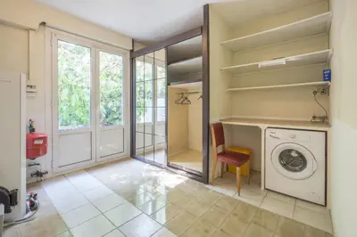 a laundry room with a washing machine and a chair at La fourmi in Cannes