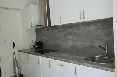 a kitchen with a sink and white cabinets at Air-conditioned Apartment of 90 m2 only 200 meters away from the Croisette in Cannes