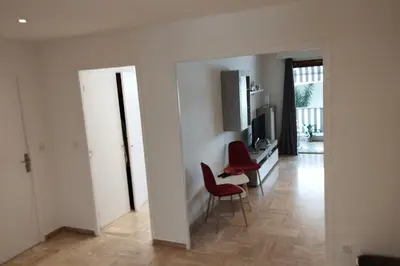 a living room with two red chairs and a television at Air-conditioned Apartment of 90 m2 only 200 meters away from the Croisette in Cannes