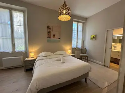 a bedroom with a large white bed and a chandelier at C025 Villa Toscane Bel Appartement Bourgeois in Cannes