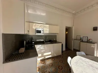 a kitchen with white cabinets and a counter top at C025 Villa Toscane Bel Appartement Bourgeois in Cannes