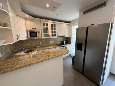 a kitchen with white cabinets and a stainless steel refrigerator at C058 Bel appartement spacieux terrasse Centre in Cannes