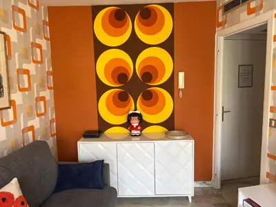 a living room with an orange and yellow wall at Studio next to the beach in Cannes