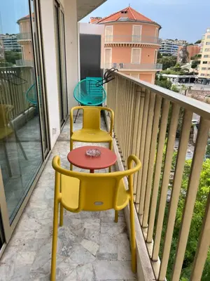 a balcony with two chairs and a table at Studio next to the beach in Cannes