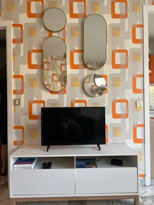 a tv on a white cabinet in a living room at Studio next to the beach in Cannes