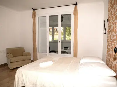 a bedroom with a bed and a chair and a window at La Maison By Simone T4 in Cannes