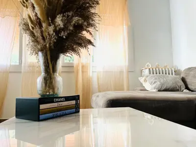 a living room with a table with a vase on it at La Maison By Simone T4 in Cannes