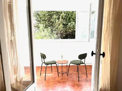 a table and chairs on a patio with a window at La Maison By Simone T4 in Cannes