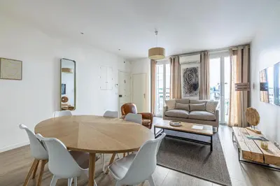 a living room with a table and chairs and a couch at 64m2 face Majestic - 50m palais & plages in Cannes