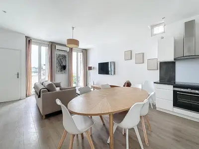 a kitchen and living room with a table and chairs at 64m2 face Majestic - 50m palais & plages in Cannes
