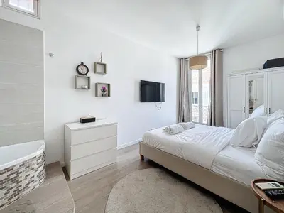 a white bedroom with a bed and a bath tub at 64m2 face Majestic - 50m palais & plages in Cannes
