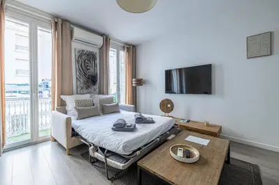 a bedroom with a bed and a table and a tv at 64m2 face Majestic - 50m palais & plages in Cannes