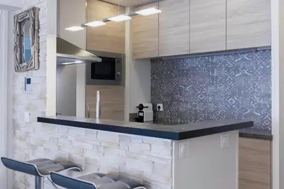 a kitchen with a counter with stools around it at Amandier du Moure Rouge in Cannes