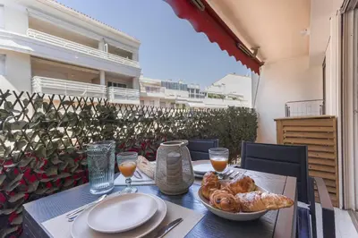 a table with food and drinks on a balcony at Amandier du Moure Rouge in Cannes