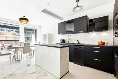 a kitchen with black cabinets and a counter top at SUNBLUE - Accommodation Center Cannes & port in Cannes