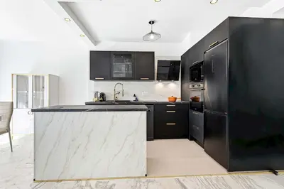 a kitchen with black cabinets and a white counter top at SUNBLUE - Accommodation Center Cannes & port in Cannes