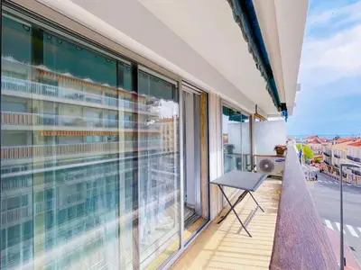 a balcony with a chair and a view of the street at SUNBLUE - Accommodation Center Cannes & port in Cannes