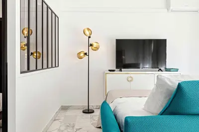 a bedroom with a bed and a lamp and a chair at SUNBLUE - Accommodation Center Cannes & port in Cannes