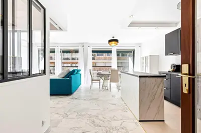 an open kitchen and living room with a blue couch at SUNBLUE - Accommodation Center Cannes & port in Cannes